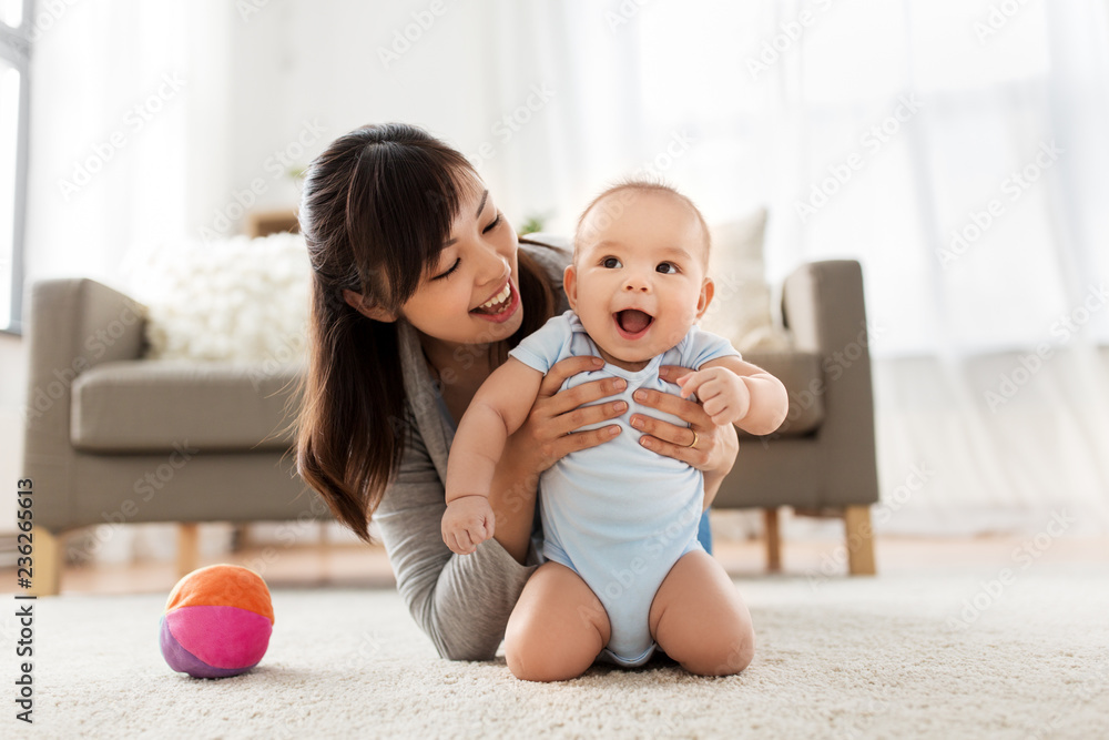 family and motherhood concept - happy smiling young asian mother with little baby at home